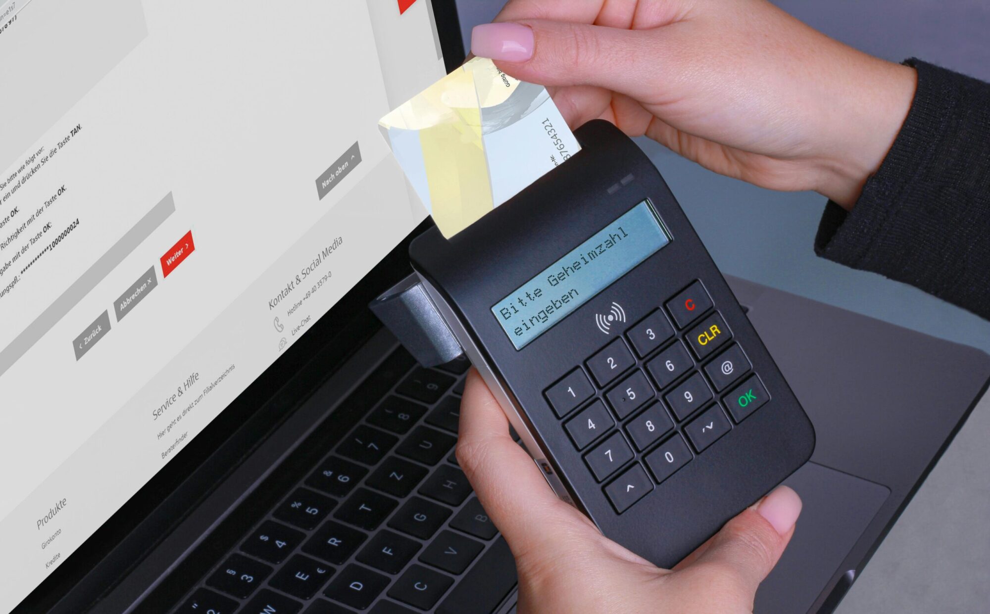 A person using a card reader for a secure online payment with a laptop and PIN entry.